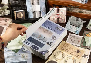 Dettaglio di un kit scrapbooking vintage con meccanismi a strappo e motivi floreali retrò