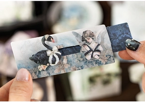 Close-up of vintage manual pull-out card with black swan and angel illustration