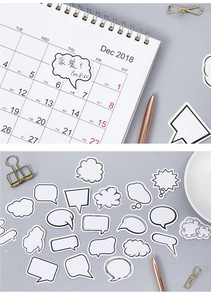 Detail van minimalistische zwart-wit tekstballonstickers op een kalender en verspreid