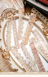 Detail of vintage hollow lace paper strips with musical notes for scrapbooking DIY