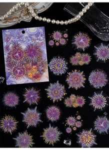 Macro detail of firework theme stickers with gold foil accents on black background
