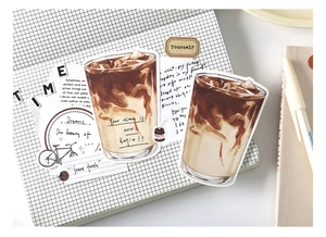 Detail showing vintage watercolor iced coffee stickers on a grid journal with a white pen