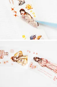 Detail of vintage character stickers being applied with tweezers on floral paper tape