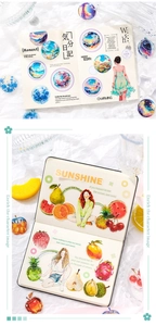 Dettaglio di adesivi scrapbooking da sogno con personaggi e frutta su un taccuino