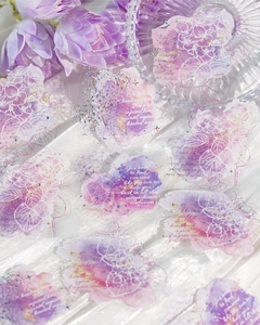 Macro shot of purple floral PET stickers with gold foil details on white silk