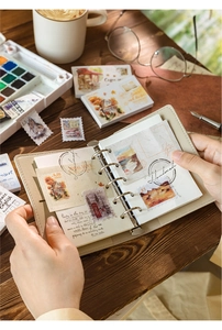 Detail of vintage stamp themed 6-hole binder notepad with retro collage and beige leather cover