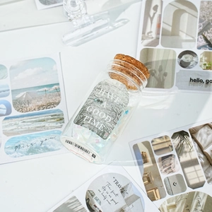 Miniature glass bottle with cork stopper featuring forest themed stickers and sequins