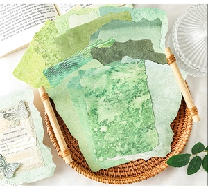 Detalle de papel de scrapbooking de acuarela verde con mariposas en bandeja rústica