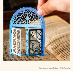 Detail of vintage blue laser-cut paper window with functional opening for DIY journaling