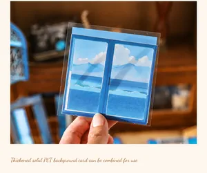 Macro shot of transparent PET background card showing hand-painted blue sky mountain scenery