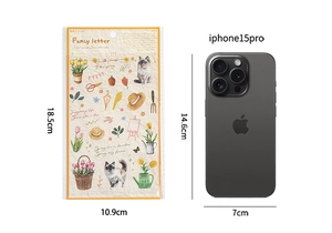 Détail d'autocollants vintage de jardin comparés à un iPhone 15 Pro pour la taille