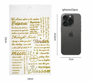 Autocollants artistiques dorés avec phrases manuscrites à côté d'un téléphone de taille