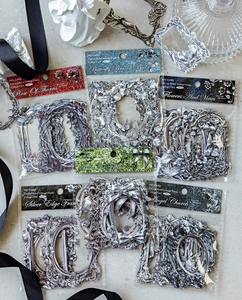 Makroaufnahme von Vintage-Silber-Hohlkarten mit geprägten Blumenmustern für DIY