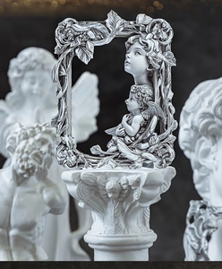 Detailansicht eines silbernen Vintage-Reliefrahmens mit barocken Engels-Dekormotiven