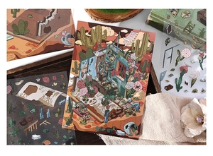 Macro detail of desert ruin theme PVC stickers and postcard on a vintage wooden tray