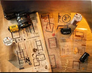Detail of retro film frame PET tape with vintage camera props on a warm wood desk