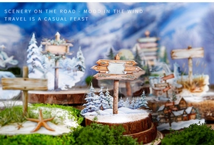 Close-up of winter landscape acrylic ornaments with solid wood bases on mossy wood