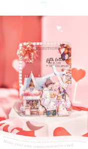 Close-up of DIY acrylic frame with romantic anime couple art, pearls, and strawberry accents