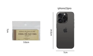 Vintage scrapbooking paper pad 9.8x7cm compared with iPhone 15 Pro for scale