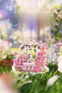 Detail of scenery-themed sticker featuring a flower-framed well on green grass
