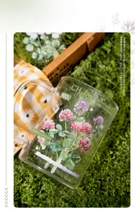 Detailed view of floral four-leaf clover stickers on a clear glass mug for DIY projects