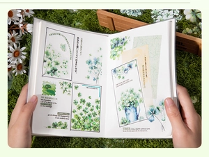 Macro detail of Lucky Clover botanical stickers applied on a DIY creative journal page