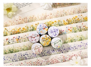 Detailed view of floral washi tape rolls with realistic wildflowers for DIY scrapbooking