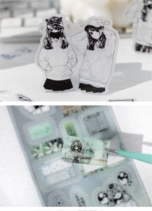 Detail showing anime girl PET stickers with glitter finish and tweezers for scrapbooking