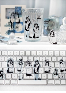 Detail of translucent anime girl stickers on glass and keyboard for DIY journals