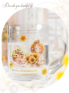 Detailed close-up of a glass mug with sunflower girl illustration on white lace cloth