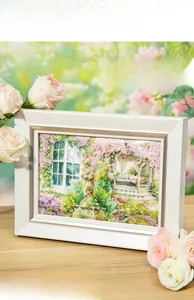 Floral PET stickers featuring garden scenes used in a white decorative photo frame