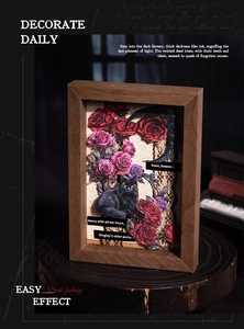 Macro detail of Gothic 3D shadow box with black cat, red roses and vintage book pages