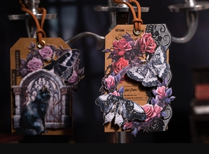 Detail of gothic dark fantasy stickers featuring black cat and moth on kraft tags with cords