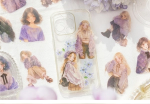 Detailed close-up of cute purple girl stickers and floral decals on a transparent phone case