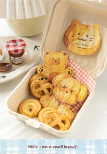 Close-up of cute animal-themed sticky notes and cookies in a paper lunch box