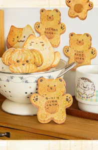 Cute animal-shaped cookie sticky notes scattered on a wooden table for DIY journaling