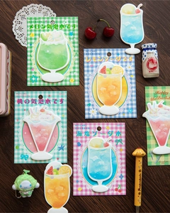 Detailed close-up of dessert-shaped sticky notes on a rustic wooden background