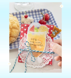 Detail of cute bear-themed stationery card with twine tie in a cozy cafe setting