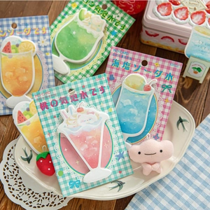 Detailed view of MO·CARD shaped sticky notes with watercolor beverage patterns in a dish