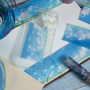 Transparent phone case with white fabric flower and blue sky clouds aesthetic design