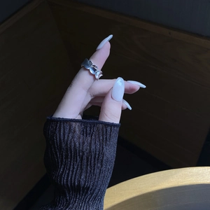 Detailed view of S925 sterling silver ring with textured fish scale pattern on model's finger