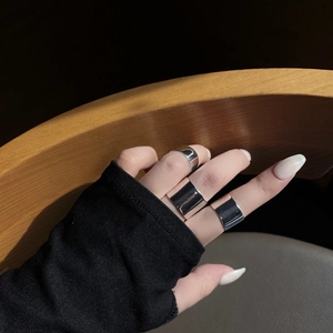 Polished silver wide band rings set on hand with a minimalist aesthetic and glossy finish