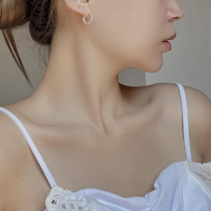 Detailed close-up of S925 sterling silver egg-shaped bead earrings on model
