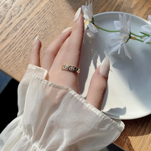 Close-up of golden irregular hammered texture ring worn on hand in a warm setting