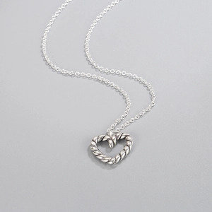 S925 sterling silver heart necklace with vintage twisted texture on a gray background