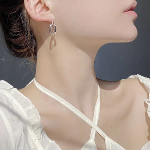 Close-up of geometric irregular double rectangular drop earrings in polished silver finish