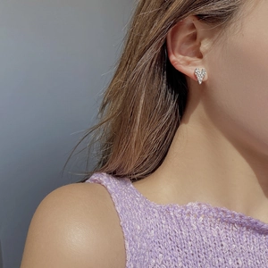 Close-up of irregular 925 sterling silver heart stud earring with pavé crystals on ear