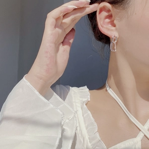 Minimalist silver interlocking double loop earrings worn by a model in natural lighting