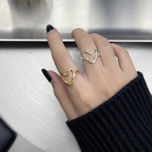 Close-up of woven 925 sterling silver heart-shaped rings in gold and silver finishes