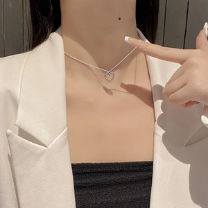 Detail of S925 sterling silver heart necklace worn on a neck for a chic style